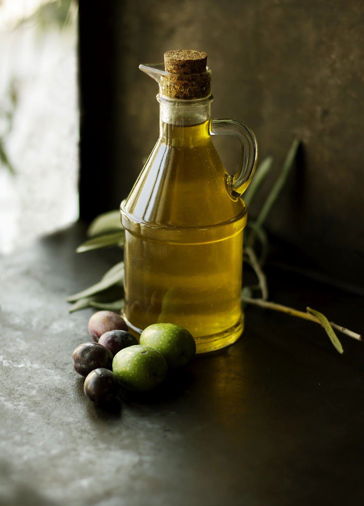 Carafe d'huile d'olive et olives sur une table